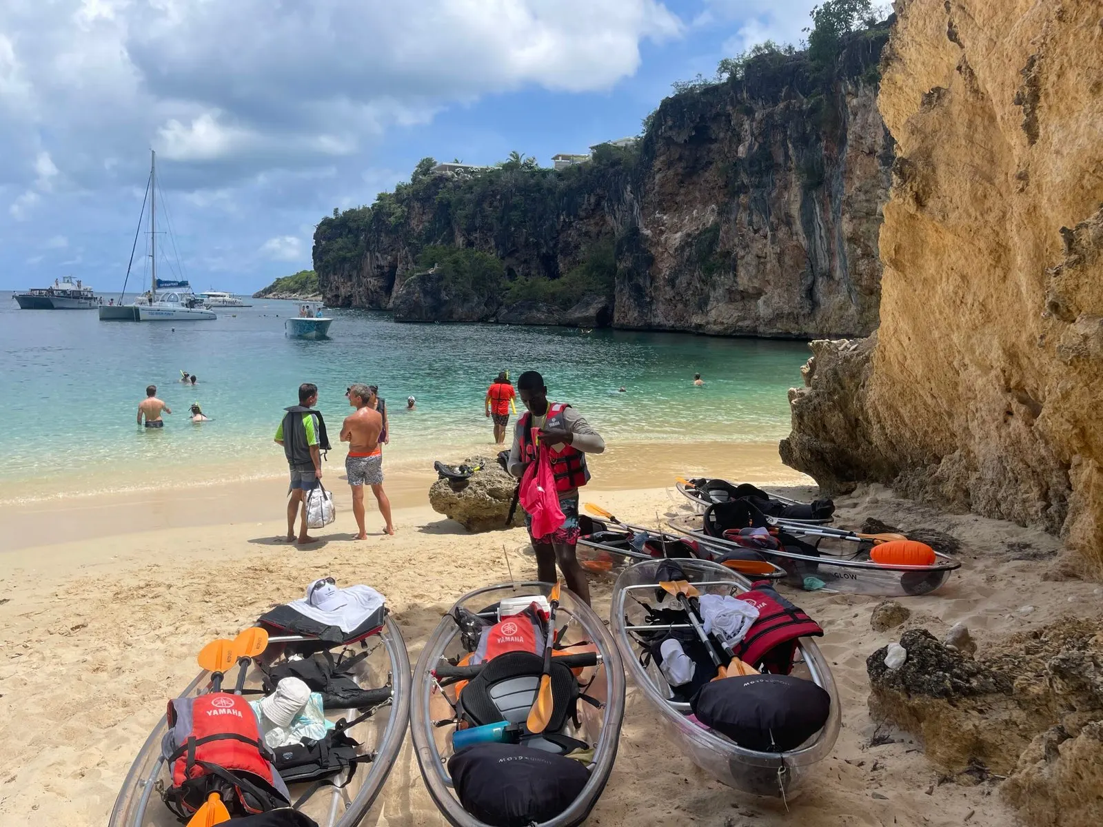 Clear kayaks pulled up on the sand at the Little Bay snorkel stop