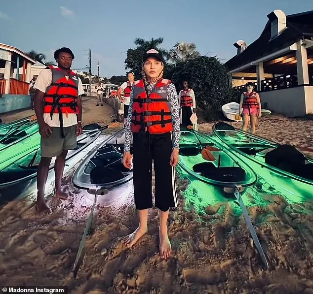 Madonna and family getting ready to launch the lit clear kayaks from the beach