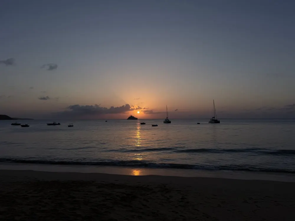 The bay at dusk with sailboats resting at anchor